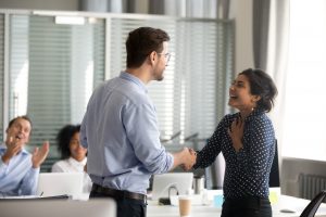 boss shaking employee's hand, congratulating