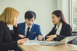three professionals having a discussion at a table