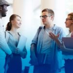A group of four students having a conversation and smiling.