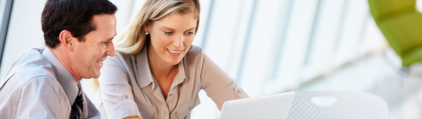 woman and man staring at laptop